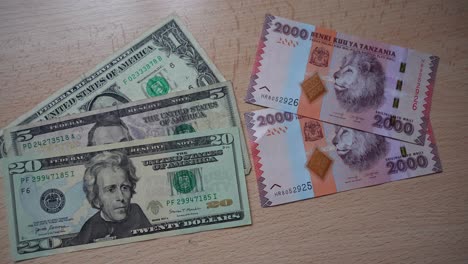 usd banknotes next to tanzanian shilling banknotes on table