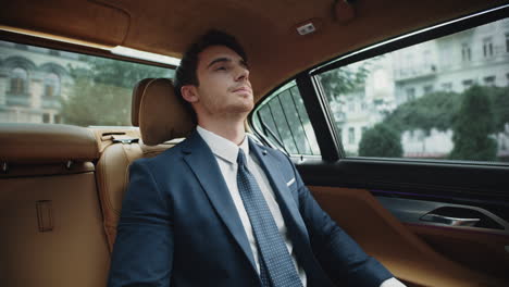 tired business man resting at back seat of modern car. businessman relaxing