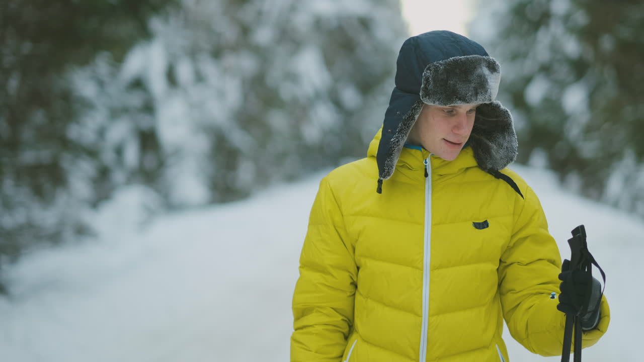 Uomo sorridente con gli sci e sua moglie che guardano qualcosa di curioso durante un'escursione in una foresta invernale