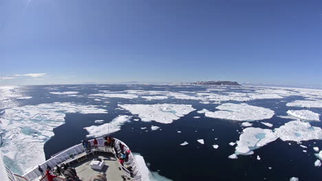 a ship travels through the northwest passage in east greenland with icebergs surrounding