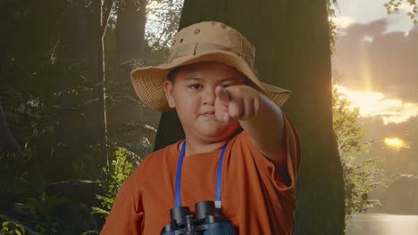 niño asiático con sombrero y binoculares usando lupa señalando con el dedo hacia usted, sacudiendo la cabeza agitando el dedo índice mientras explora la naturaleza del bosque. niño investigador que no muestra ningún gesto, cerrar