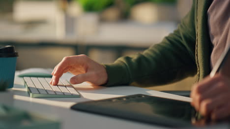 busy man talk smartphone at workplace closeup. designer hand typing keyboard