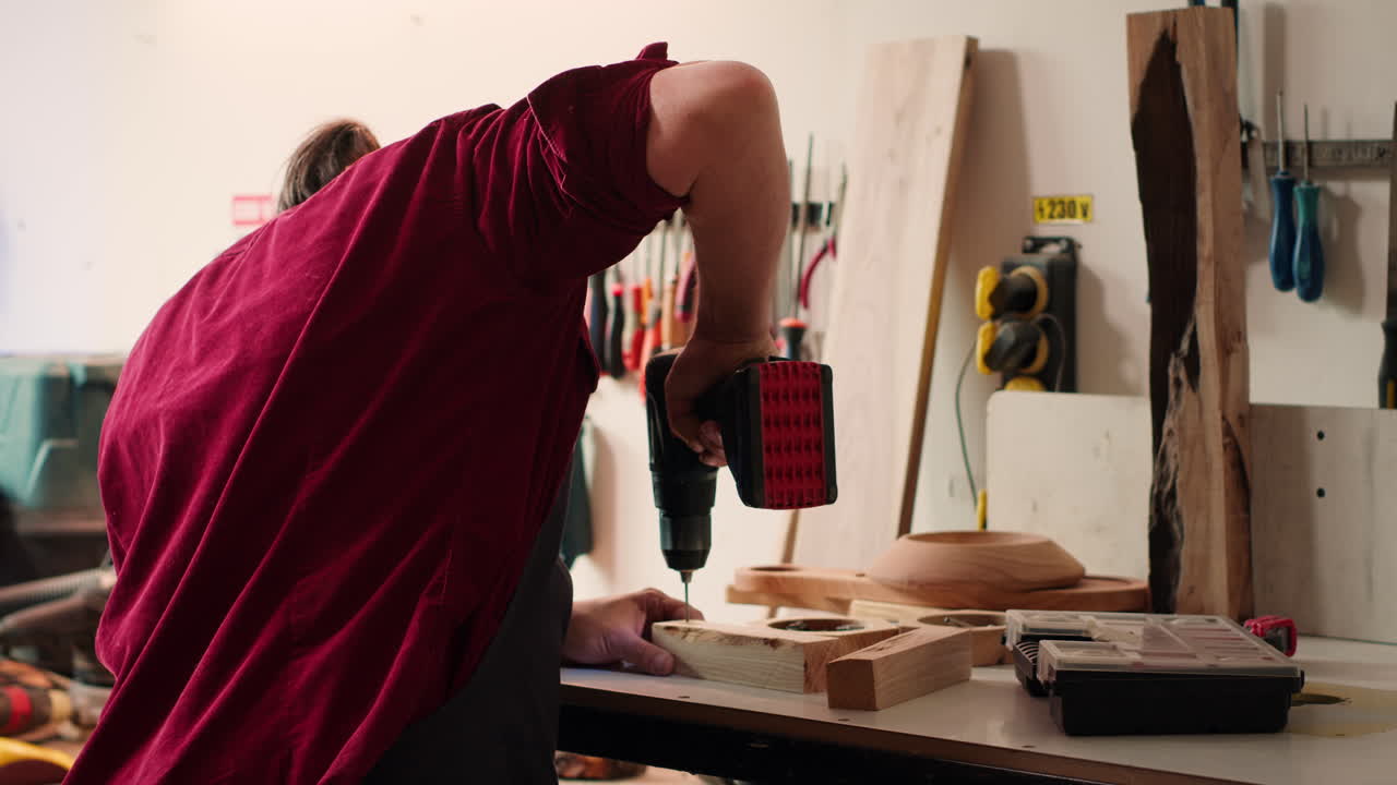 조립 작업실 에서 구 을 만들기 위해 전력 드릴 을 사용 하는 목공