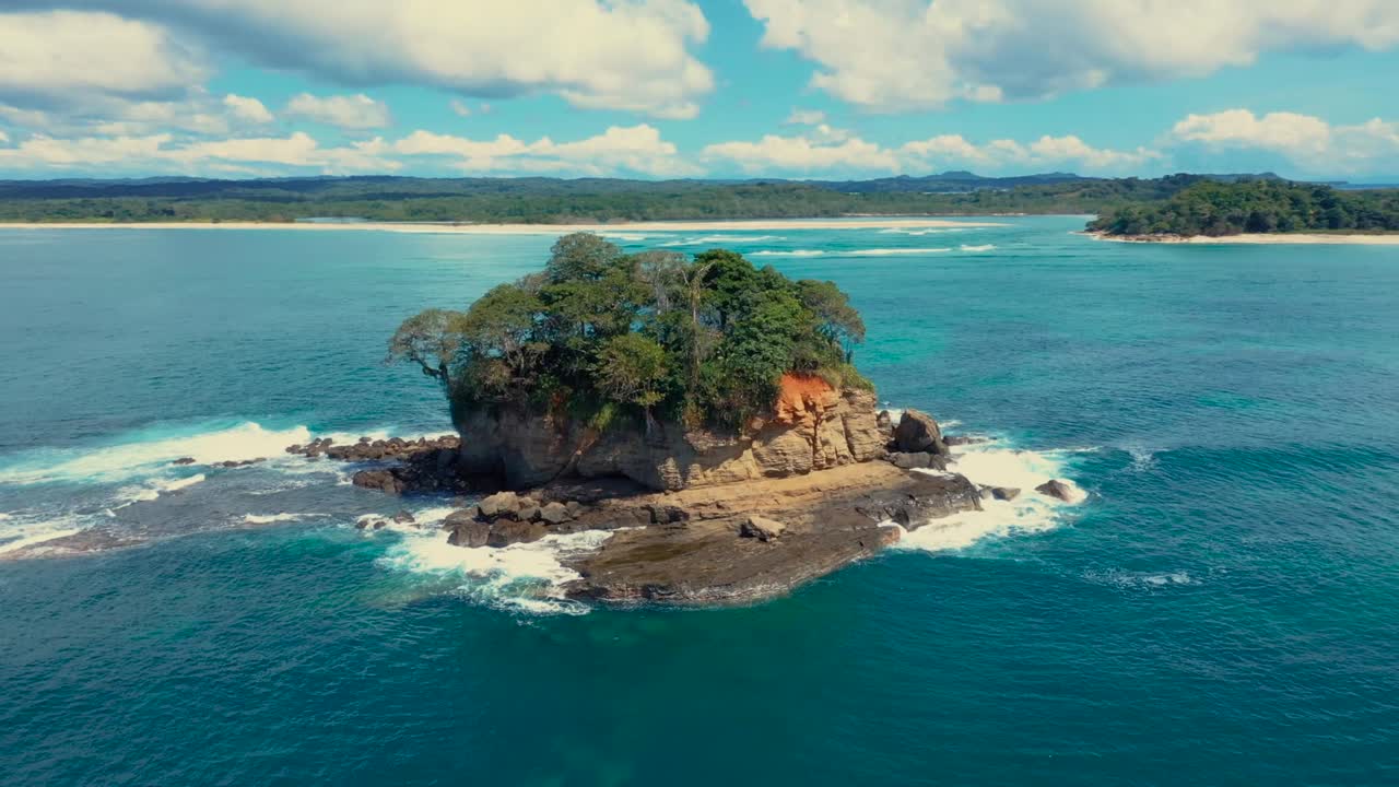 imágenes de drones orbitando una isla rocosa