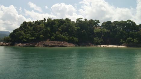 Imágenes-Aéreas-De-Drones-De-4k-Sobre-El-Agua-Hacia-El-Continente-Y-Sobre-Los-árboles-Que-Revelan-Un-Pequeño-Pueblo-Y-Una-Carretera-En-Koh-Chang,-Tailandia