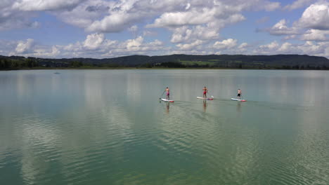 stand-up-paddling en el kochelsee cerca de múnich, alemania en el borde de los alpes de baviera