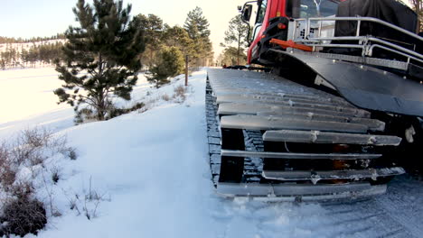 low angle of the snowcat grooming a trail on the snow