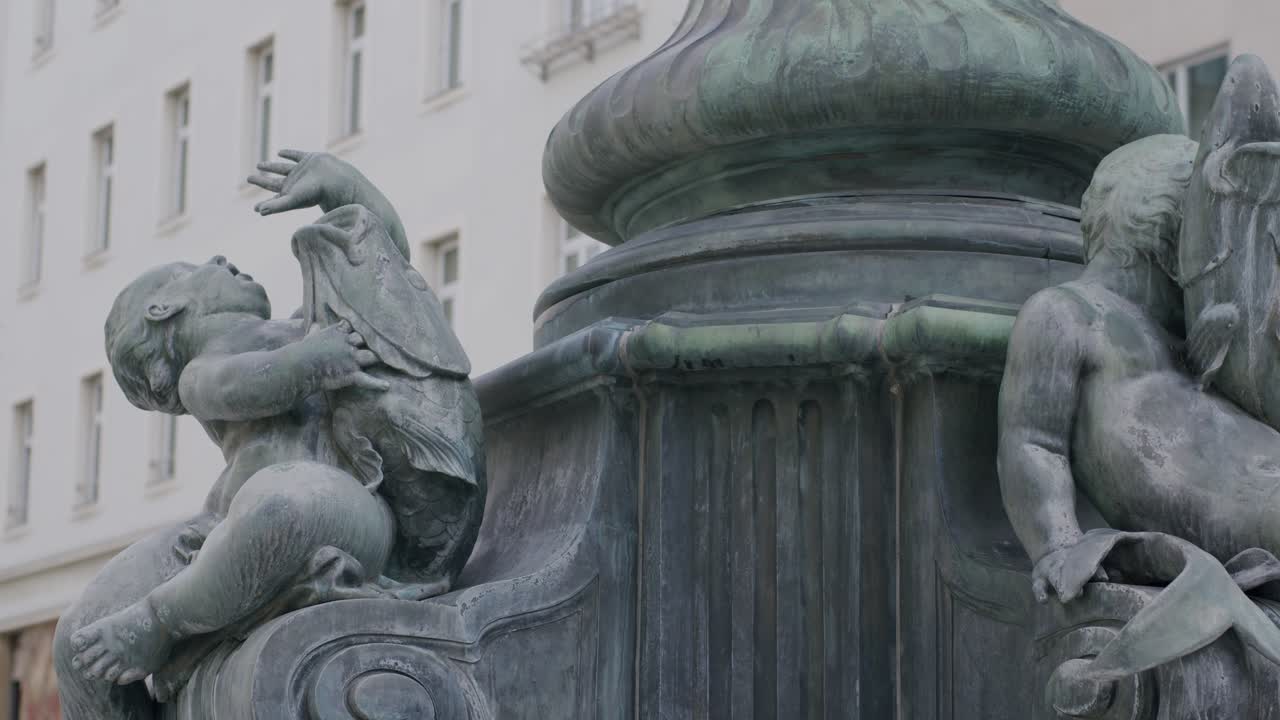 Two bronze cherubs on Vienna's Donnerbrunnen fountain, close-up urban detail