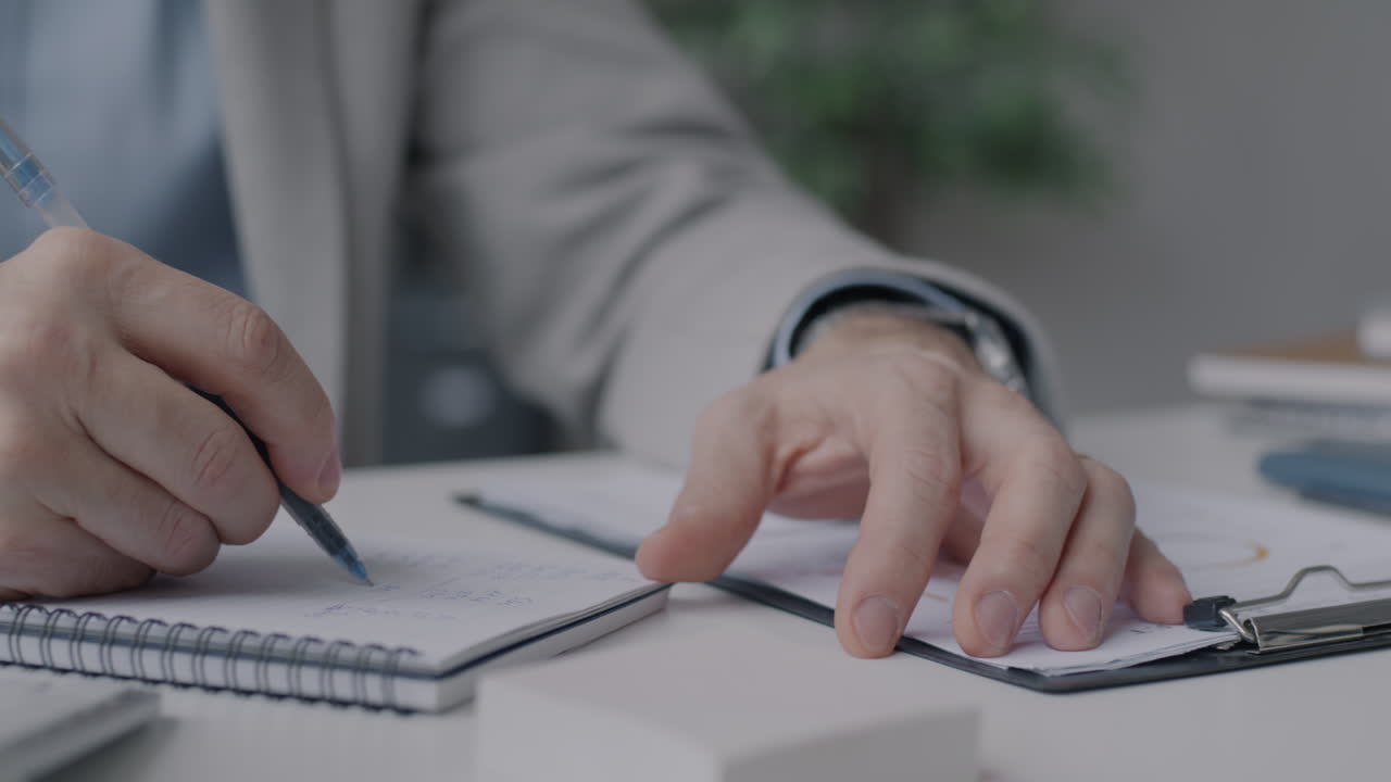 un hombre de negocios tomando notas en su escritorio.