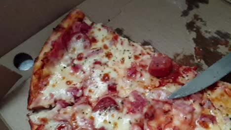 pizza perfecta, queso cheddar extra fundido, salami extra y aderezos de pepperoni servidos calientes, rebanados con un cuchillo de sierra de acero inoxidable