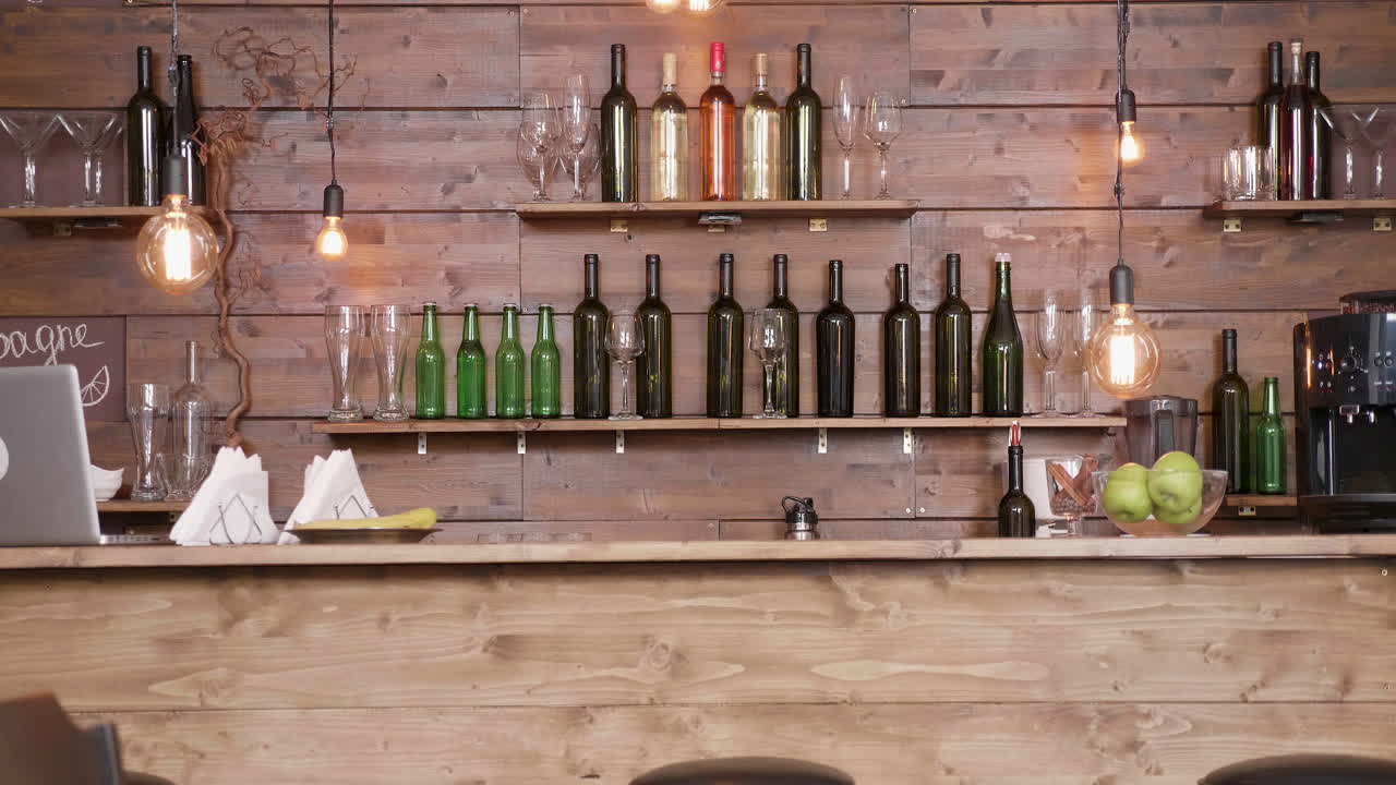 A rustic bar with wine bottles and glasses on shelves