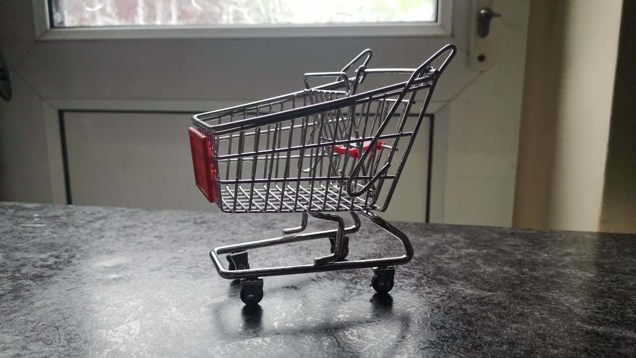 Mini empty shopping cart online home supermarket concept copy space closeup orbit left