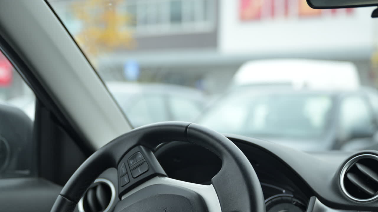 자동차 스티어링 과 대시보드, 겨울에 큰 쇼핑몰의 주차장에서 차량