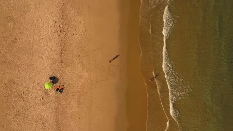 Aéreo-Vertical.-Alejándose-Gente-En-La-Playa-De-Arena