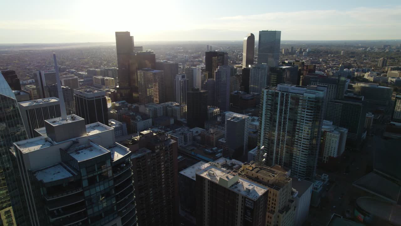Denver, Colorado, EUA. Vista aérea da área metropolitana ao nascer do sol. Arranha-céus e rodovias. Afastamento lento entre edifícios