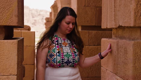 Traveling-Woman-Exploring-Intricate-Architecture-Of-Petra,-Historic-City-In-Jordan