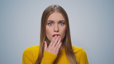 closeup disappointed woman looking at camera on grey background in studio.