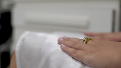 detail of the painted nails of a bride that is getting ready at beauty salon on wedding day