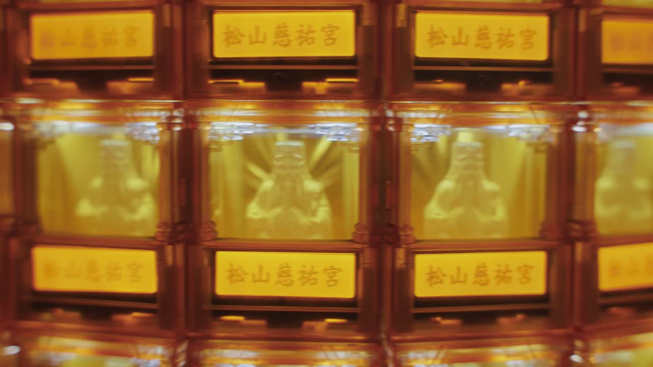 Close-up of golden Buddha statues glowing in individual illuminated niches at Ciyou Temple in Taiwan, symbolizing devotion, peace, and spiritual reverence in a sacred Buddhist space