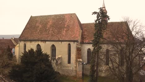 beautiful view of sighisoara medieval buildings on cloudy day with the clock tower on center