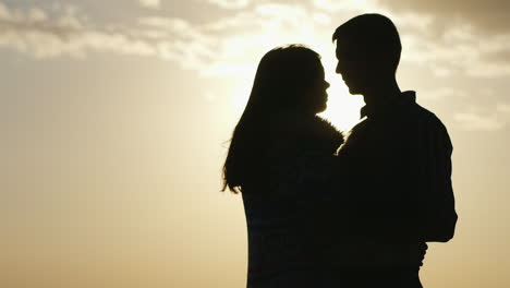 silhouettes of young men and women against the sky couple in love