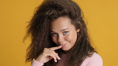 caucasian curly haired woman smiling to the camera.