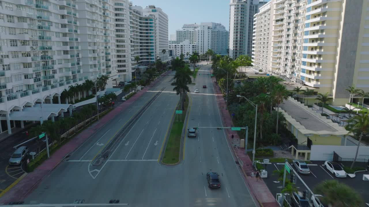 seguimiento hacia adelante de vehículos que conducen por una carretera principal de varios carriles en un distrito urbano moderno. palmeras a lo largo de la carretera. miami, ee.