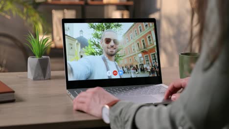 Chica-Hablando-Por-Videollamada-En-Una-Laptop-Con-Un-Hombre-Guapo-Y-Alegre-Con-Gafas-De-Sol-Que-Camina-Por-La-Ciudad