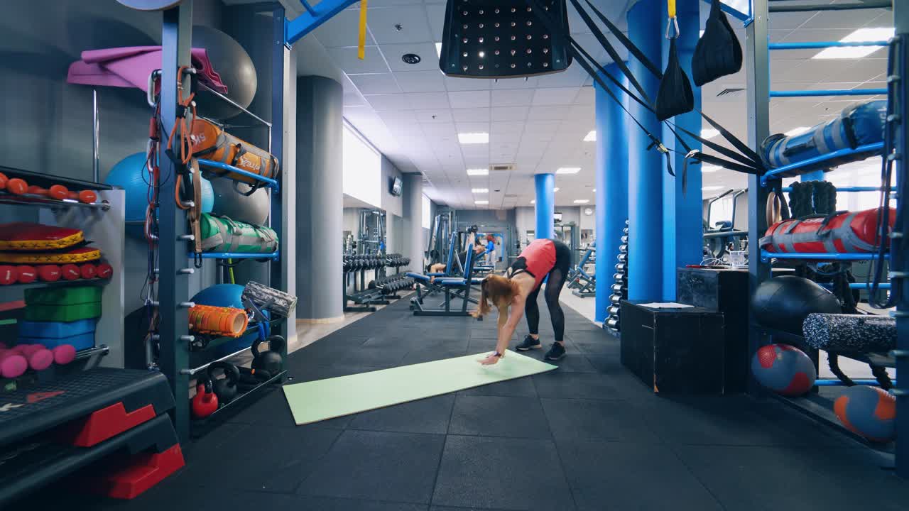Female exercising in the gym. Woman doing workout on mat in gym