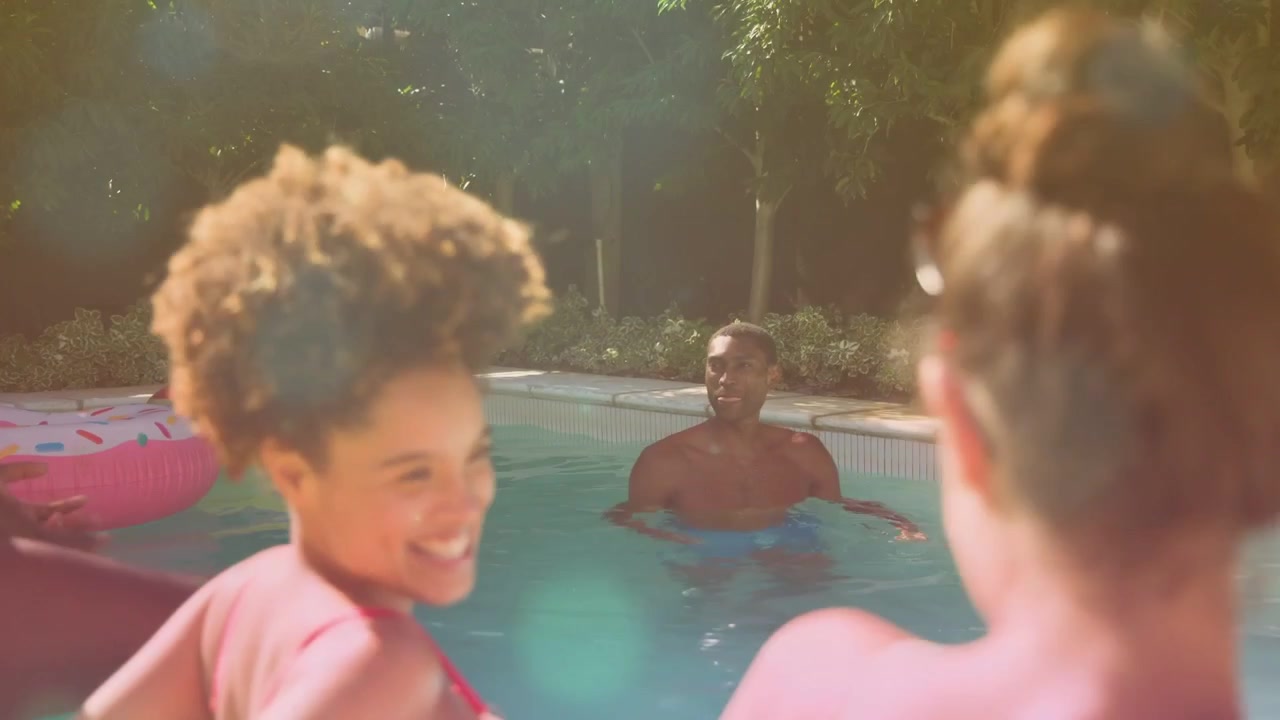 Woman leaning, starting chat, touching friend, causing motion labels on pool float and beer for ads