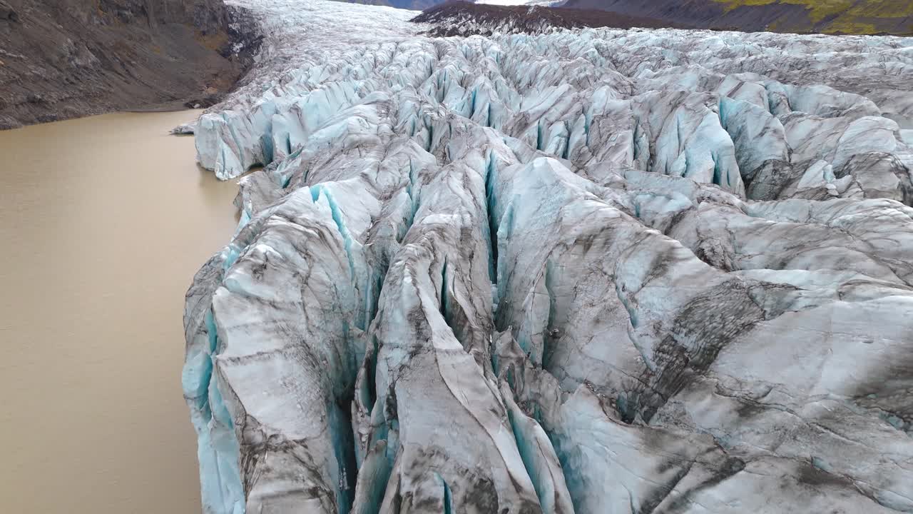 Flying above the glaciers of S&oacute;lheimaj&ouml;kull, the turquoise blue crevasses are covered with black dust