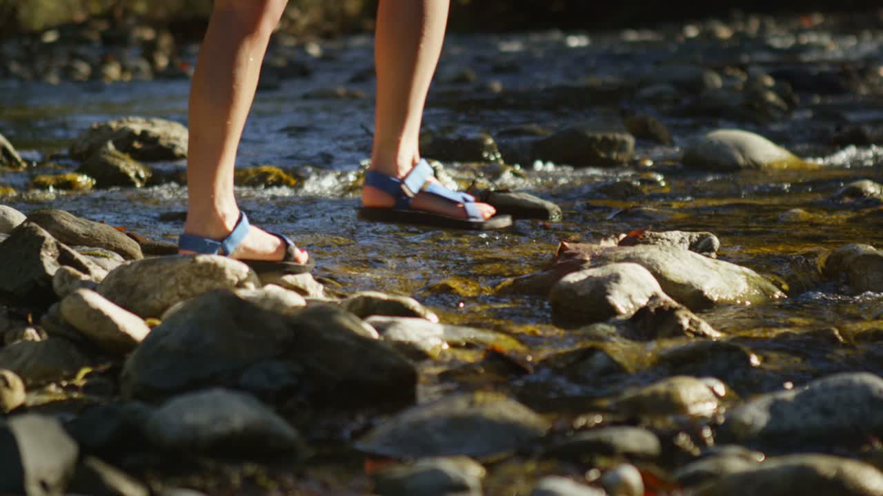숲속의 개울을 건너는 커플의 다리에 근접 촬영