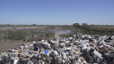 wide view of a dumping ground with bulldozers working in the background