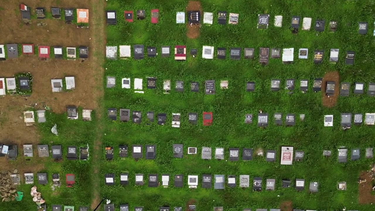 Ripresa aerea orbitale cinematografica del Cimitero Pubblico di Alfonso a Cavite, Filippine, con strade circostanti, strutture vicine e una composizione provinciale equilibrata dall'alto.