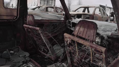 destroyed car interior melted down to metal frame with broken glass and debris - aftermath of oregon wildfires - 4k