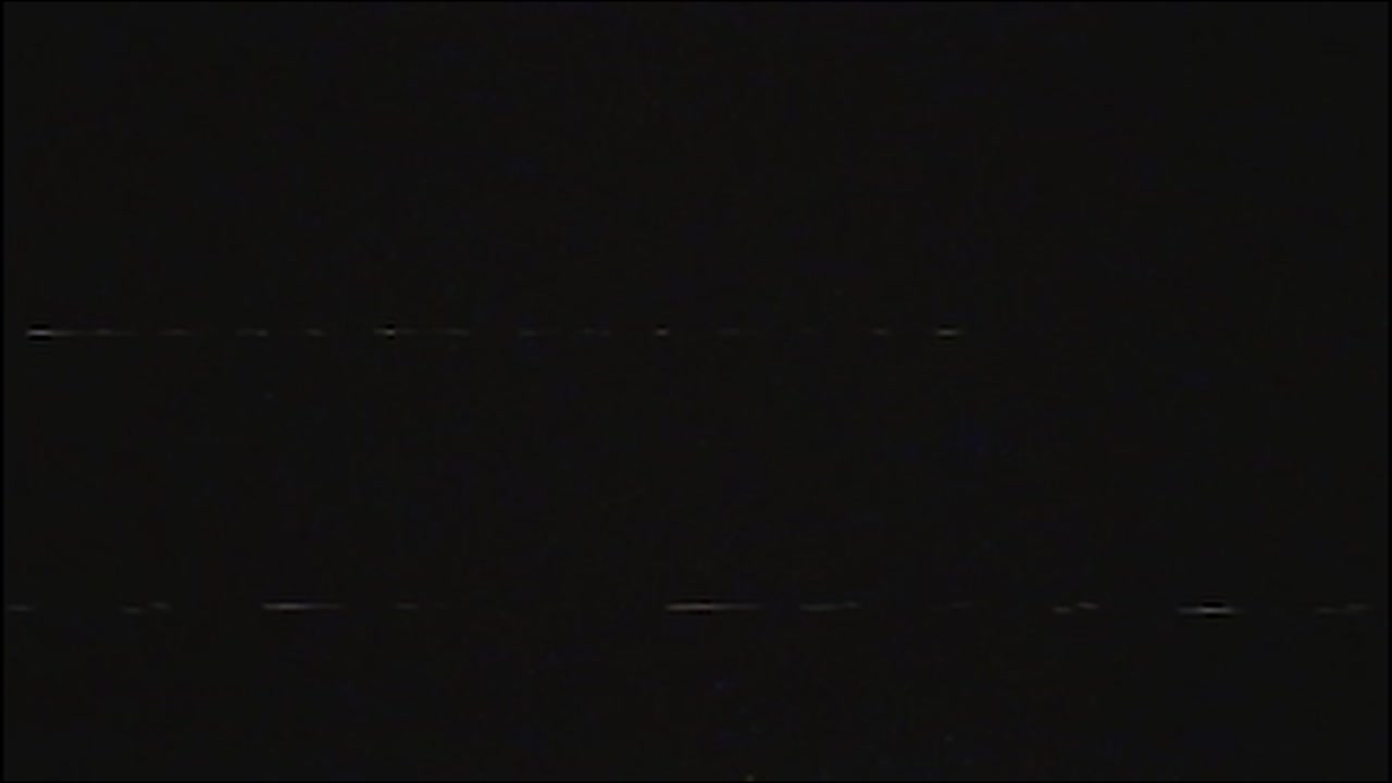 Authentic vhs tape noise with subtle static and glitches on a dark, faded screen. Perfect overlay for creating a retro 80s or 90s look