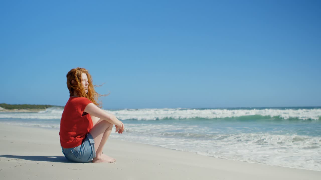 모래 위에 앉아서 바다를 바라보는 여자 4k