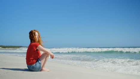 woman sitting on sand and looking at sea 4k