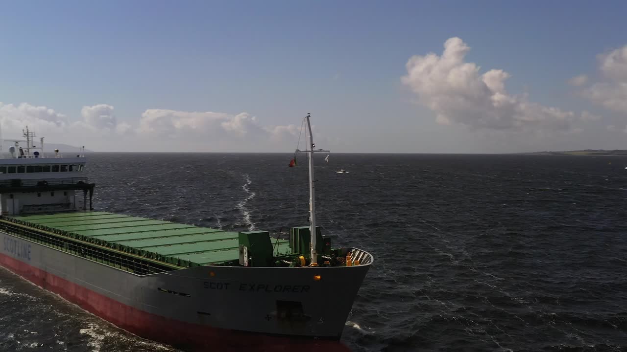 Aerial orbit around front bow of large ferry barge maritime goods transport vessel in open ocean