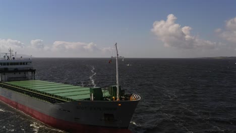 aerial orbit around front bow of large ferry barge maritime goods transport vessel in open ocean