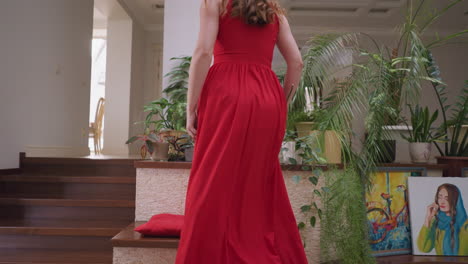 woman in a red dress sitting on stairs in a home