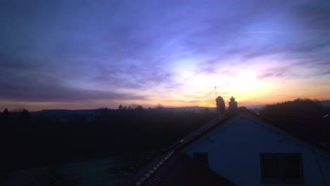 purple and blue early morning dramatic sunrise over village in germany in 4k