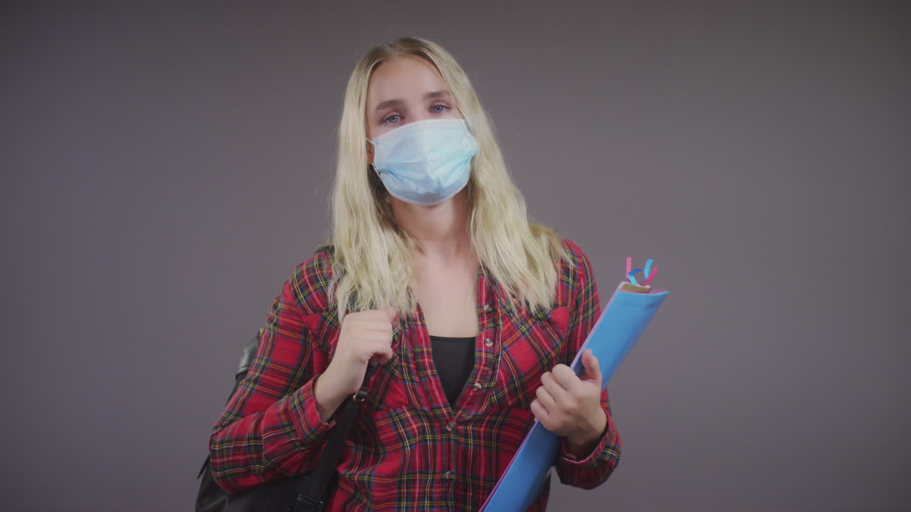 молодая блондинка-студентка в маске на лице