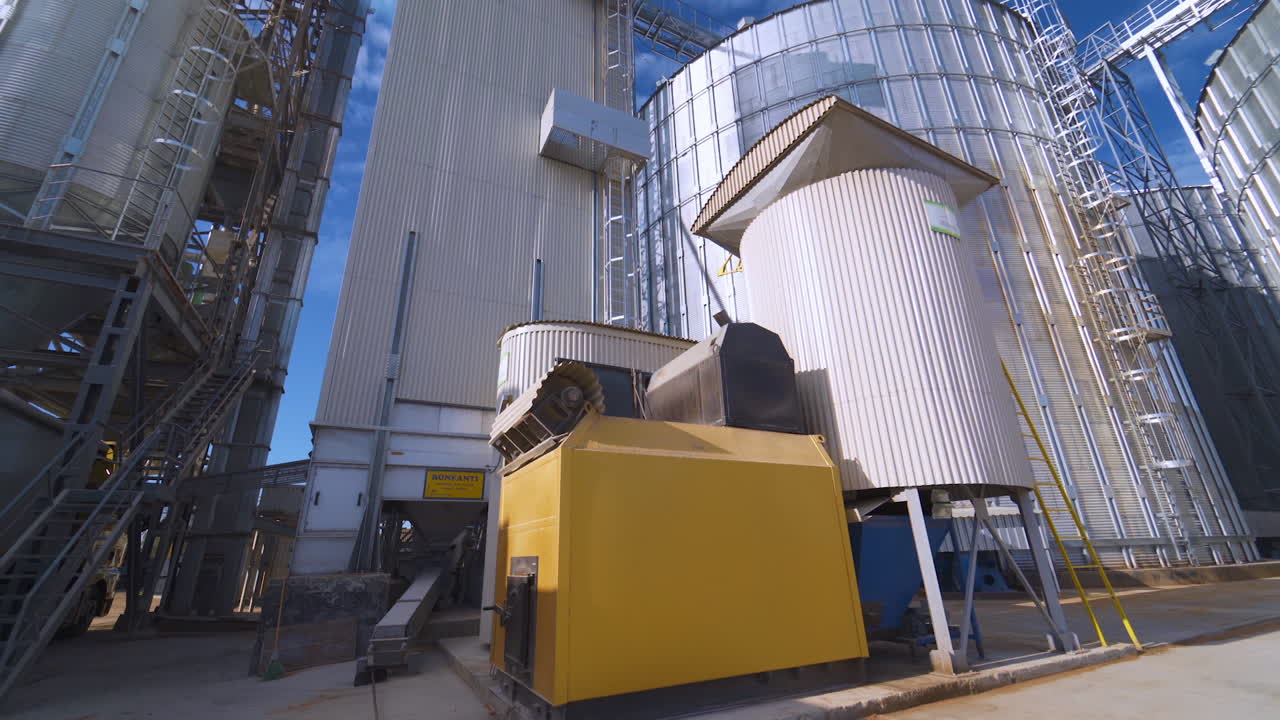 Plant for processing and silos for drying cleaning and storage of agricultural products, flour, cereals and grain. Silver tanks close-up.