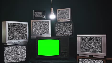 old tv sets with static turned on green screens. lots of chromakey tvs in a dark room
