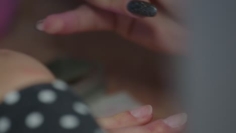 a manicurist painting a woman's nails in the beauty salon, close up with selective focus