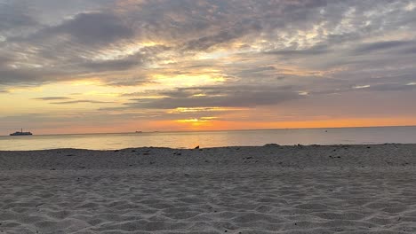 lapso de tiempo en la playa del mar báltico con la puesta de sol y la arena en primer plano