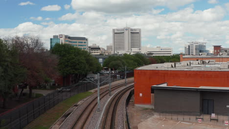 Forwards-fly-above-empty-electrified-double-track-railway-line-leading-through-town.-Dallas,-Texas,-US