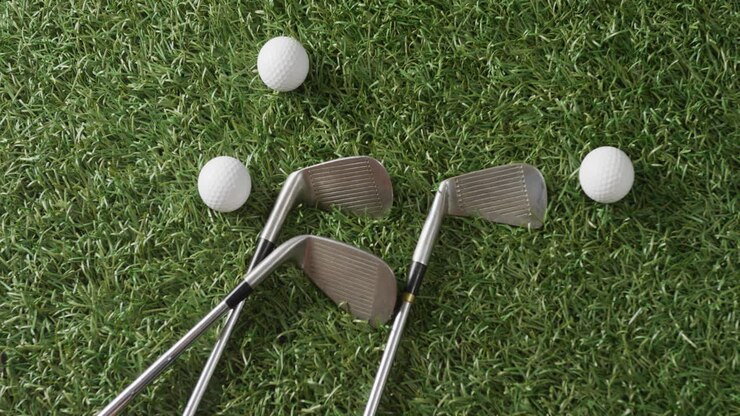 Primo piano di mazze e palline da golf su erba, spazio per il testo, slow motion
