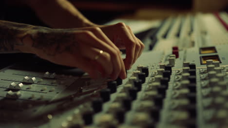 manos de hombre tocando deslizadores en el estudio de grabación